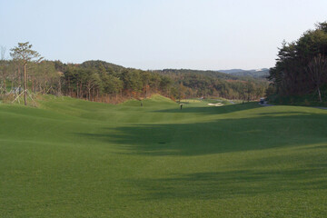 A view of the golf course with people playing golf