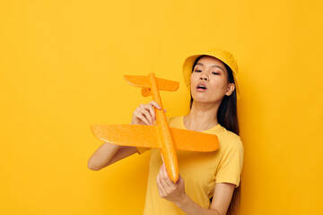 woman with Asian appearance with a yellow plane in his hands a toy isolated background unaltered