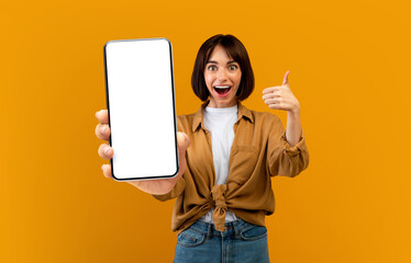 Pretty millennial woman holding smartphone with empty screen and gesturing