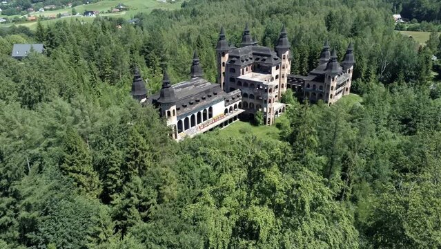 Fly above tree tops and reveal majestic building of Lapalice castle