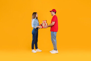 Courier Giving Gift Boxes To Customer Woman Over Yellow Background