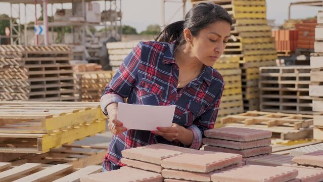 Woman manager keeps records of building materials in the open area of a construction store