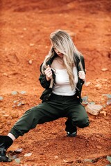 Girls in a post-apocalyptic place, a quarry with red earth and stones in work clothes