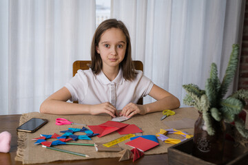 a beautiful teenage girl makes origami