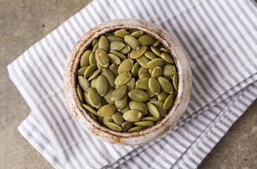 Pumpkin seeds in a bowl, superfoods. Copy space
