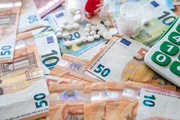 different pills calculator and euro banknotes. medical concept