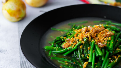 Stir-fried morning glory in a black dish 