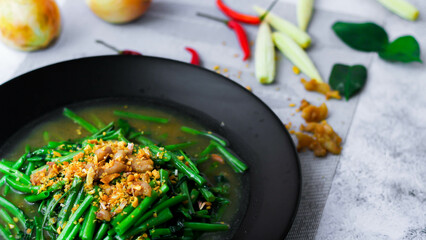 Stir-fried morning glory in a black dish 