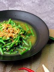 Stir-fried morning glory in a black dish 