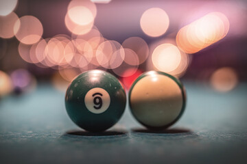 Billiard colored balls and wooden cue are scattered on a beautiful green table for the game.