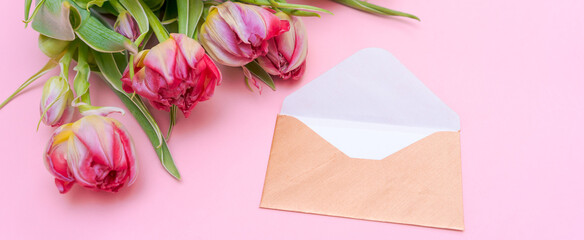 Bouquet tulips and an envelope written on pink background. Concept international women's day, mother's day and easter