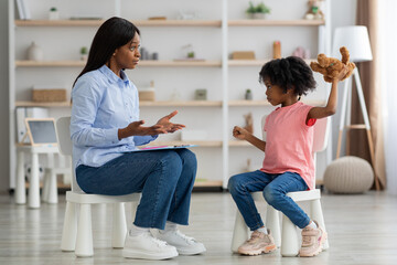 Agressive black girl having session with child psychotherapist