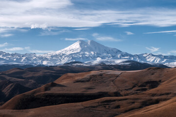 Great nature mountain range. Amazing perspective of  Elbrus with autumn fields, blue sky background.