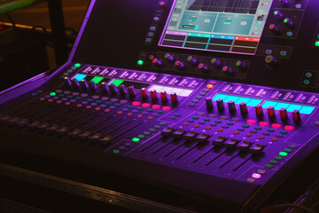 Modern digital mixing console with faders, control buttons and touch screen. Selective focus