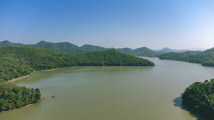Fototapeta premium Area of Huai Krathing reservoir for Rafting and Eating at Loei Province, Thailand. Beautiful natural landscape of the river, mountain, blue sky with green forest and bamboo raft shelter.