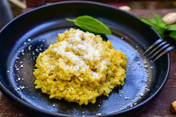  Italian  creamy Risotto Milanese  with Parmesan cheese and fresh basil on rustic background