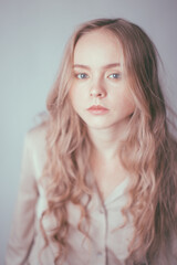 Naklejka premium very gentle and heavenly portrait of a young girl with a doll-like appearance and white hair on a blue background. Light defocus and art noise on the frames