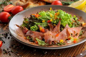 fresh salad with tuna, tomatoes and corn in a flat round plate
