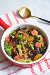a plate of stir fry vegetables and sausages named cap cay