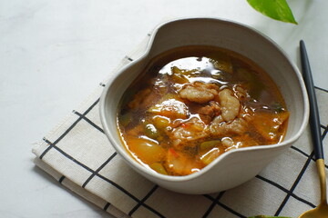 a bowl of beef cooked in spicy soup named asem asem in Bahasa 