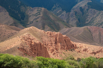 Beautiful red clay mountains eroded on wind. Red mountains or red canyon on the way from Assy plateau to Bartogai reservoir. Mountain canyon landscape.