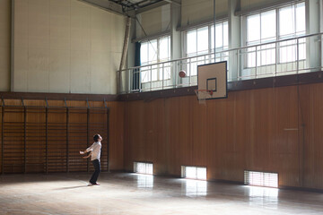 体育館でフリースローをする男子生徒