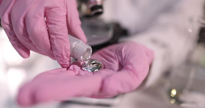 Scientist chemist in gloves pouring liquid metal mercury into hand closeup 4k movie