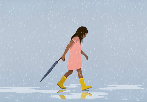 Girl carrying closed umbrella in rain
