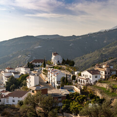 Fototapeta na wymiar small village in the backcountry of Andalusia with whitewashed houses and a chapel on the hill