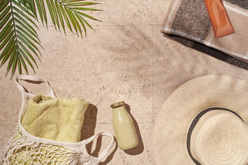 Fototapeta na wymiar Summer sunny beach concept flat lay.Hat, string bag with towel and bottle, palm leaves, accessories. High quality photo