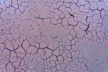 Cracked and damaged painted surface of a building or wall. Texture, aged paint background