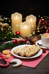 Sliced Traditional Christmas stollen cake with marzipan and New Year decorations on wooden background