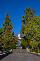 Obraz premium A large beautiful monument in antique style stands on a pedestal against a clear blue sky on a sunny day