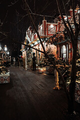 Christmas decorations on Christmas trees at night and children's attractions are out of focus, entertainment park, new year's lights