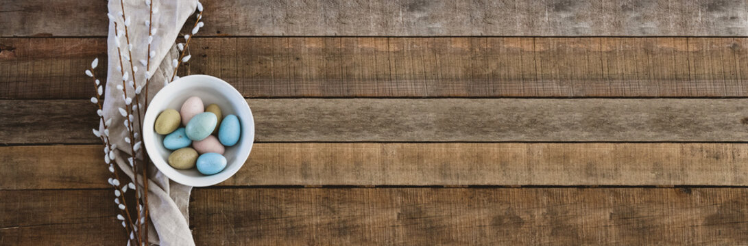 A Bowl Full Of Colorful Easter Eggs On The Table Made Of Bare Wood Planks