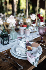 banquet table is decorated with plates, cutlery, glasses, candles and flower arrangements