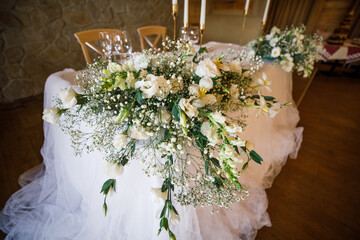 banquet table is decorated with plates, cutlery, glasses, candles and flower arrangements