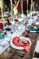 banquet table is decorated with plates, cutlery, glasses, candles and flower arrangements