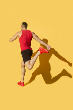 Man in red with shadow running on yellow background

