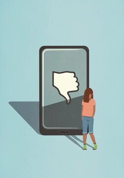 Sad girl standing next to thumbs down icon on smart phone screen

