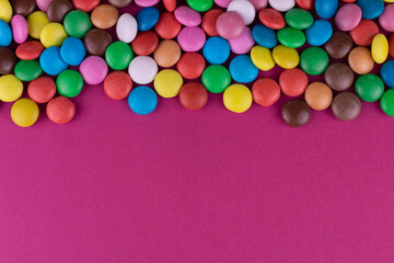 Obraz premium Multicolored candies on a pink background.Copy space.