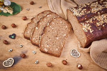 Schwarzbrot mit Haseln&uuml;ssen geschnitten auf Holzbrett