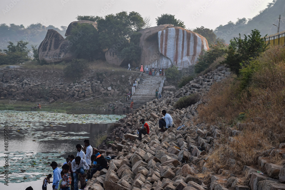 Wall mural stock photo of holy bhima river bank near lord mallaya temple, people taking ritual bath early in th