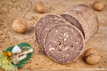 Roggen-Walnuss-Brot geschnitten auf Holzbrett mit Deko