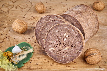 Roggen-Walnuss-Brot geschnitten auf Holzbrett mit Deko