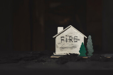Word fire written on a small wooden house.