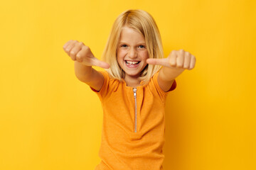 Young blonde girl in a yellow t-shirt smile posing studio childhood lifestyle unaltered