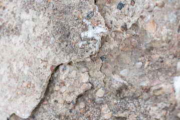 Cracked concrete wall gray cement surface background.cracked grey stone wall in winter.close-up.