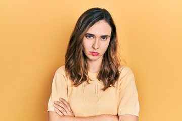 Young hispanic girl wearing casual clothes skeptic and nervous, disapproving expression on face with crossed arms. negative person.