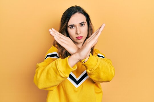 Young hispanic girl wearing casual clothes rejection expression crossing arms doing negative sign, angry face